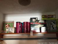 Photo of boxed Pfaltzgraff Winterberry items and other boxed serveware on shelf