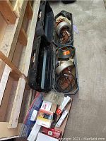 Two General Super-Vee pipe cleaning machines in black carrying cases with some packed items and loose parts adjacent