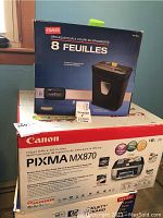 Photo showing boxed Staples 8-sheet shredder on top of Canon PIXMA MX870 printer box.