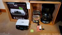 Full lot displayed: Krups PG 70 Panini Grill box, white sandwich maker, chrome vintage Sunbeam toaster, black drip coffee maker.