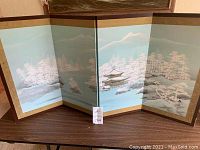 Full view of the four-panel folding screen extended on tabletop