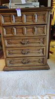 Front view showing all 5 drawers, carved panel design, brass hardware, and chest dimensions.