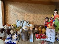 Full view of miscellaneous salt and pepper shakers and figurines including Buddhas, mushrooms, whale, cat, snails, and roosters.