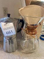 Photo showing the aluminum stovetop espresso maker and the Chemex glass coffee maker with paper filters inserted in the wooden collar.