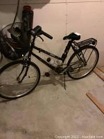 Full side view of the black AutoBike Classic bicycle showing frame, wheels, front basket, and rear carrier rack