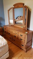 Full view of wood dresser with attached tri-fold mirror, showing overall condition and style.