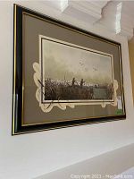 Framed signed and numbered print hanging on wall, view showing subject and frame