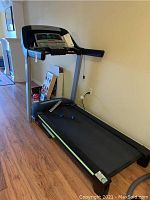 Full view of treadmill showing frame, belt and tools on running surface