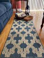 Full view of the runner rug, baskets with books and papers near a sofa