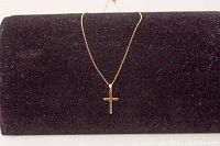 Full view of the 16 inch gold chain necklace with cross pendant displayed on a black velvet background.