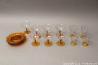 Full view of the set showing 7 champagne glasses, 7 yellow cornflower glass plates, and 4 juice glasses.