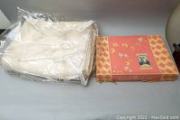 Two wool blankets, one cream-colored wrapped in plastic and one boxed Kenwood Baby Blue blanket.