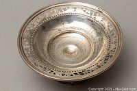 Top view of round sterling silver candy dish showing tarnishing and decorative pierced rim edge