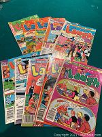 10 Archie Comics Laugh Series comic books arranged on a green surface showing colorful front covers with various Archie characters.