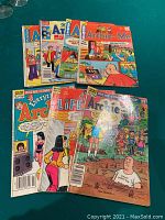 Seven Archie comic books laid out showing colorful covers and characters from the series.