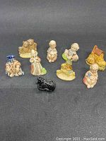 Eight Wade Whimsie nursery rhyme figurines on a black background showing detail and color variances.