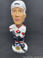 Front view of the Chris Pronger bobblehead in Team Canada uniform holding hockey stick, standing on base with gold medal detail