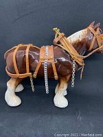 Side angle showing full length of ceramic horse and detail of leather harness with chain and studs