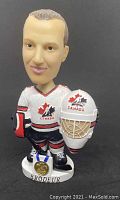 Front view of the Martin Brodeur bobblehead showing the uniform, medal, and helmet in hand.