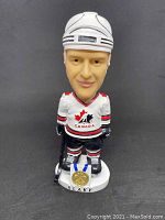 Front view of Rob Blake bobblehead in Canada hockey uniform with gold medal on base.