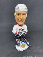 Front view of Scott Niedermayer bobblehead in Team Canada hockey uniform with gold medal on base.
