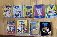 Photo of ten Family Guy season DVDs from seasons 1 to 9 arranged in two rows showing colorful cover art of the animated series characters.