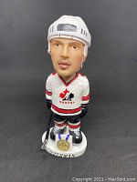 Front view of the Steve Yzerman bobblehead in 2002 Team Canada hockey uniform holding a hockey stick with gold medal on the base.