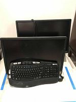Two computer monitors stacked with Logitech keyboard and mouse in front