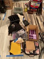 Lot overview showing various items including boxes of curlers, lotions, soaps, storage cases, and accessories on floor