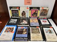 Front view of all 8 vintage 8-track tapes arranged in two rows, showing album art and labels.