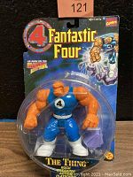 Front view of unopened Fantastic Four The Thing action figure in plastic blister pack with colorful card backing showing logo and comics art
