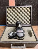 Koss K/2+2 Quadrafone right stereo headphone inside foam-padded protective hardcover case, coiled cable visible.