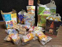 Photo showing multiple original McDonald's Happy Meal cardboard boxes, bags, and plastic-wrapped food items and toys.