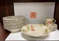 Group photo showing stacked bowls, saucers, a serving bowl, and a coffee mug with rose petal floral design.