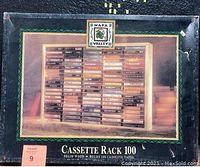 Photo of the box showing the Napa Valley brand solid wood cassette rack with capacity to hold 100 cassette tapes, with dimensions 24 x 18.5 inches.