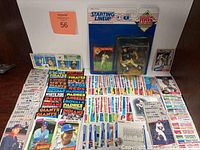 Image showing a large assortment of vintage MLB trading cards spread on a surface with visible team names and player images, alongside the sealed Paul Molitor figure in packaging