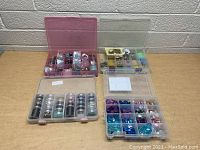 Four plastic containers filled with various beads in multiple colors and styles.