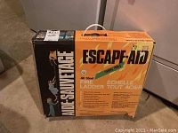 Photo showing front of original packaging box labeled Escape-Aid with fire ladder product information and branding.