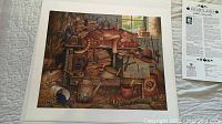 Photo showing the signed print titled "Heartland" by Charles Wyoski with detailed rustic still life imagery and the accompanying information sheet.