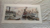 Horizontal image of the limited edition print showing detailed harbor scene with boats and city skyline, laid flat on quilted fabric.