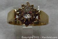 Front view of the ring on display stand showing pear-shaped center and surrounding stones