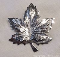 Front of the Bond Boyd sterling silver double maple leaf brooch showing engraved vein detail and polished finish.