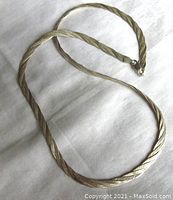 Full view of the flat braided sterling silver chain necklace on a white background showing length and texture.