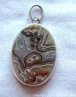 Front view of oval jasper pendant set in sterling silver, displaying natural swirling stone patterns.