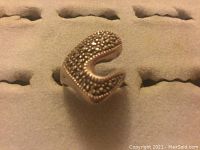 Front angled view showing the curved design with dense tiny silver bead texture on the top surface of the ring.