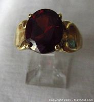 Front view showing oval red gemstone and gold shoulders
