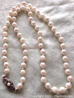 Full-length view of the 18" cultured Akoya pearl necklace hand-knotted on silk with filigree clasp
