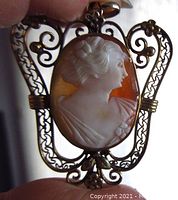 Front view of vintage gold filled shell cameo pendant showing detailed lady profile and ornate filigree design.