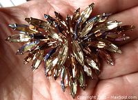 Front view of the vintage Sherman brooch showing marquise-shaped stones in light topaz, cognac, and iridescent hues with three-tier layered design.