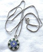 Full view of sterling silver chain with round millefiori pendant laid out flat showing overall length and pendant design
